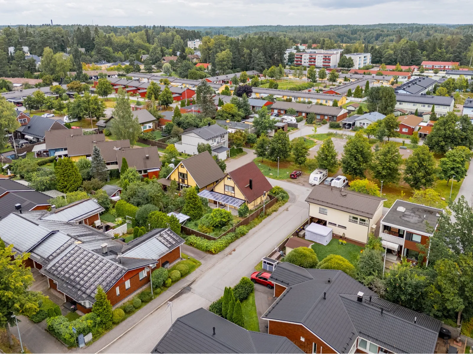 Omakotitaloalue ja rivitaloja ilmakuvassa — referenssikuva dronekuvauksesta