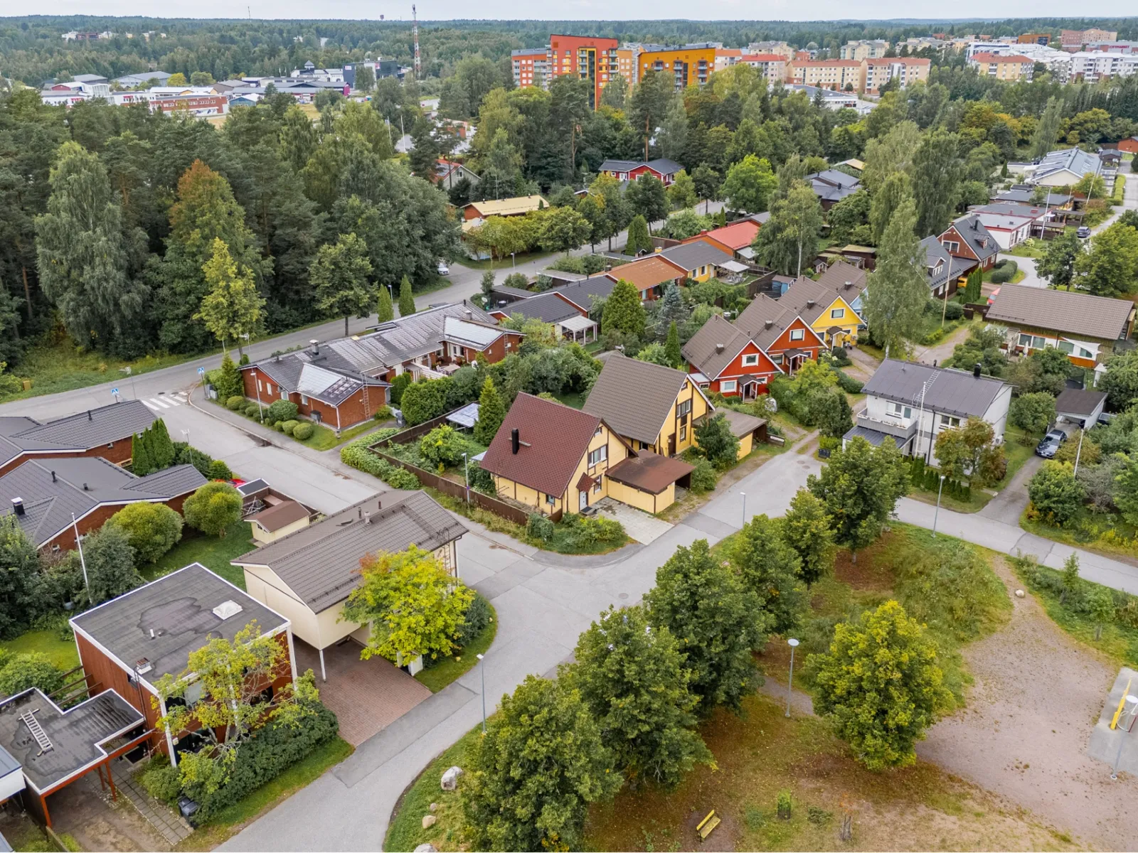 Pientaloalue ja värikkäät kerrostalot taustalla — referenssikuva dronekuvauksesta